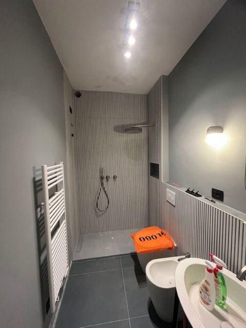 Bagno con faretti a soffitto e applique
